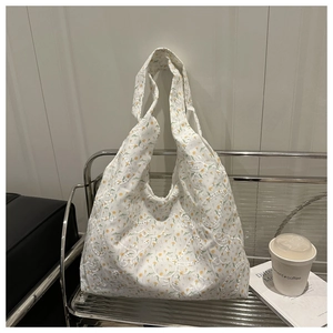 Close-up of floral canvas tote bag featuring yellow flower prints and white lace embroidery
