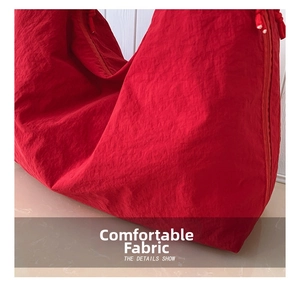 Detailed macro view of the soft wrinkled red fabric texture on a large tote bag