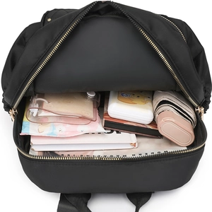 Black nylon backpack showing spacious interior with books and daily essentials