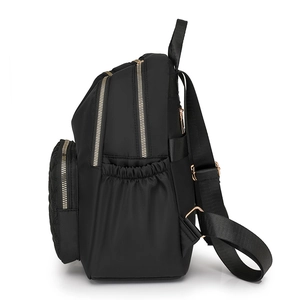 Side view of black waterproof nylon backpack with gold zippers and quilted front pocket