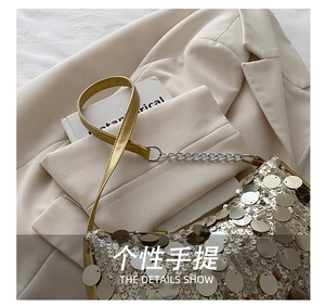Close-up of golden sequins on a stylish handbag with silver chain and leather handle