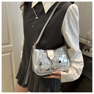 Close-up of shiny silver sequin shoulder bag with golden metallic hardware details