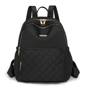 Black quilted nylon backpack with gold zippers and large front pocket on white background