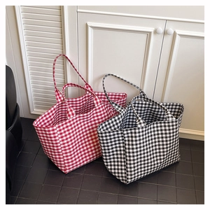 Détail de sacs cabas en toile à carreaux rouges et noirs avec double poignée spacieuse