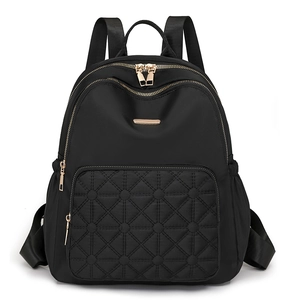 Waterproof black nylon backpack with quilted front pocket and gold zippers for travel