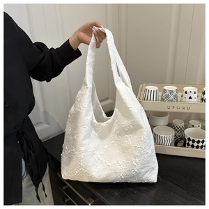 Close-up of elegant white floral embroidery on a large canvas tote bag for daily use