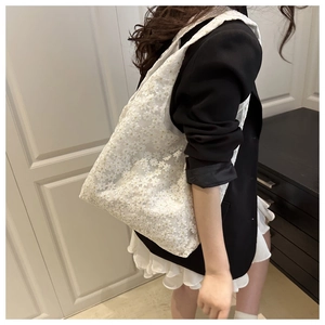 Close-up of elegant white floral lace tote bag featuring detailed daisy embroidery