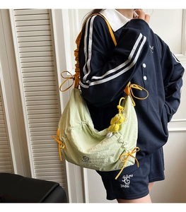 Dettaglio della borsa a spalla in nylon verde chiaro con coulisse gialla e ciondolo peluche