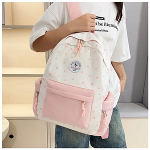 Detail of pink and white star pattern canvas backpack with front pocket and brand patch