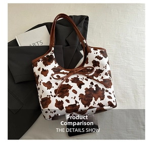 Flat lay of cow print tote bag with brown leather bow and matching shoulder straps