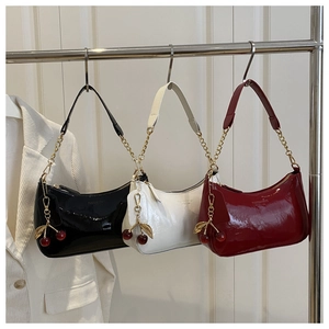 Glossy patent leather crescent underarm bags with cherry charms in black, white and red