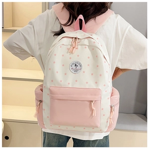 Detail of pink and white star pattern backpack with circular logo patch and front pocket