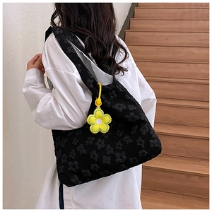 Black floral embossed tote bag with a yellow flower charm accessory for women