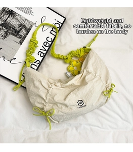 Dettaglio borsa a tracolla plissettata crema con tracolla verde neon e girasole
