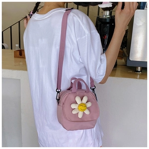 Detail of pink canvas crossbody bag featuring 3D daisy flower with a happy smiley face