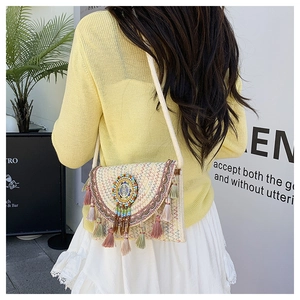Detail of Boho woven crossbody bag with colorful bead embroidery and soft tassels