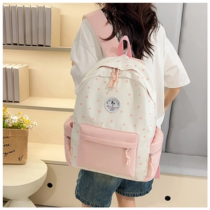 Detailed back view of a pink and white canvas school backpack with star patterns