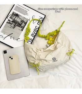 Confronto dimensioni borsa in nylon bianco con lacci verdi accanto a un iPad