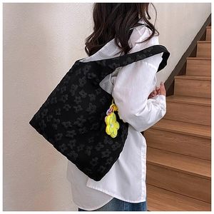 Close-up of black lace floral canvas tote bag featuring a 3D flower texture and daisy charm