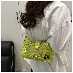 Close-up of vibrant green sequin baguette bag with metallic buckle and retro chain strap