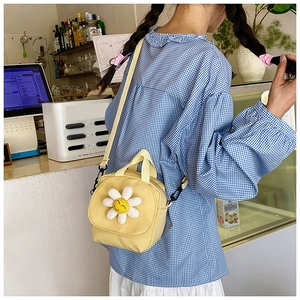 Détail du sac en toile jaune avec marguerite 3D et smiley sur la sangle réglable