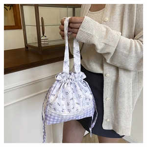 Detail of floral and checkered drawstring bag with lace trim and purple patterns