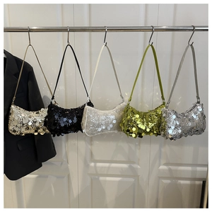 Cinq sacs hobo à paillettes en argent, or et vert suspendus sur une porte blanche