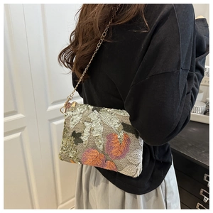 Detail of floral sequin embroidery and gold chain strap on a stylish crossbody bag