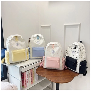 Detailed view of casual backpacks in pastel colors featuring star patterns and round logos