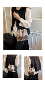 Detail of jacquard drawstring bucket bag showing front leather pockets and metal eyelets