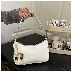 Glossy white patent leather shoulder bag with gold chain and cherry pendant detail
