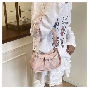 Détail du sac nuage plissé rose avec perles décoratives et chaîne en métal fleuri