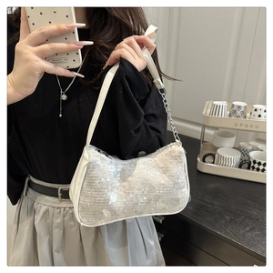 Detailed view of a white sequin underarm bag with shimmering texture and silver chain strap
