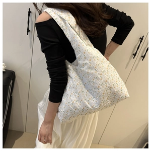 Detailed shot of a large tote bag with yellow floral embroidery and eyelet texture