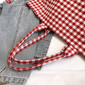 Grand sac cabas en toile à carreaux rouges et blancs sur veste en jean pour style d'été