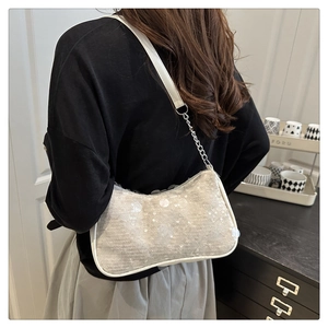 Close-up of white sequin shoulder bag with silver chain strap shown on model's shoulder