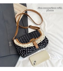 Borsa di tela a pois con pizzo e tracolla mostrata vicino a uno smartphone per misura
