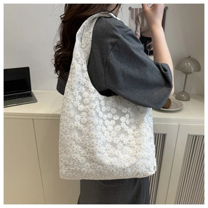 Close-up of intricate white lace floral embroidery on this stylish women's tote bag