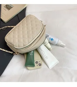 Detail of multi-layer quilted chain bag showing interior storage capacity and zippers