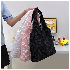 Detailed view of three 3D floral texture tote bags in white, pink, and black colors