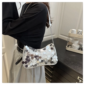 Close-up of silver sequin hobo bag with metallic round paillettes and chain strap