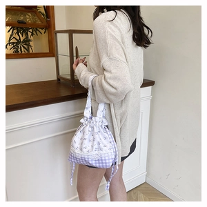 Floral and gingham bucket bag with lace detail shown in a cozy home setting