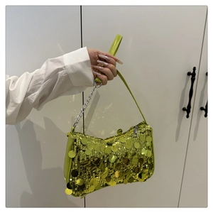 Detail of green sequin handbag featuring sparkling round metal sequins and silver chain strap
