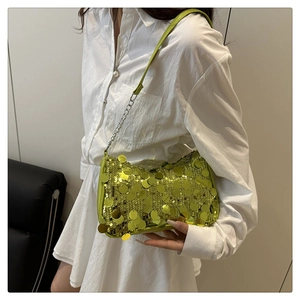 Detail of neon green paillette shoulder bag featuring oversized sequins and silver chain strap