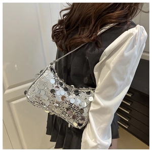 Gros plan des paillettes argentées sur le sac hobo de luxe avec bandoulière assortie