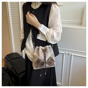 Detail of grey and brown felt bucket bag shown worn as a stylish crossbody bag