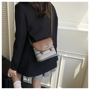 Model wearing a brown leather and striped woven crossbody bag with gold JINGFIN logo
