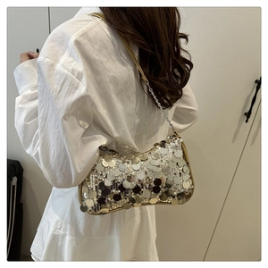 Silver sequin shoulder bag on model showing crescent shape and metallic shine