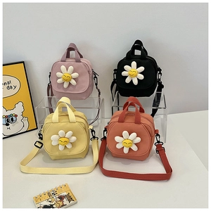 Detail of colorful canvas square bags with 3D smiling sunflower motifs and adjustable straps