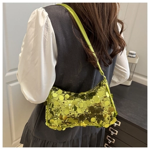 Détail des paillettes sur le sac à main jaune néon porté par un mannequin chic